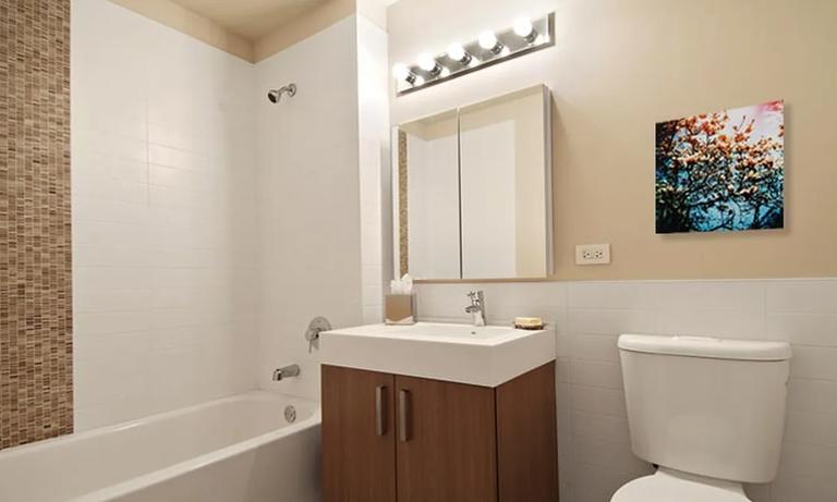 537 West 27th Street, Unit 2F Manhattan, NY 10001 - Photo 2 of 6 a bathroom with a sink mirror vanity and toilet