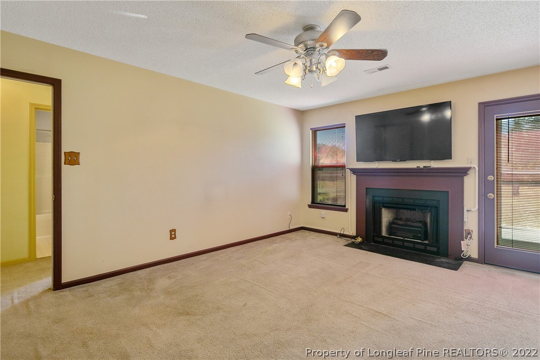 7455 Elliott Bridge Road Spring Lake, NC 28390 - Photo 12 of 49 an empty room with a fireplace and fan
