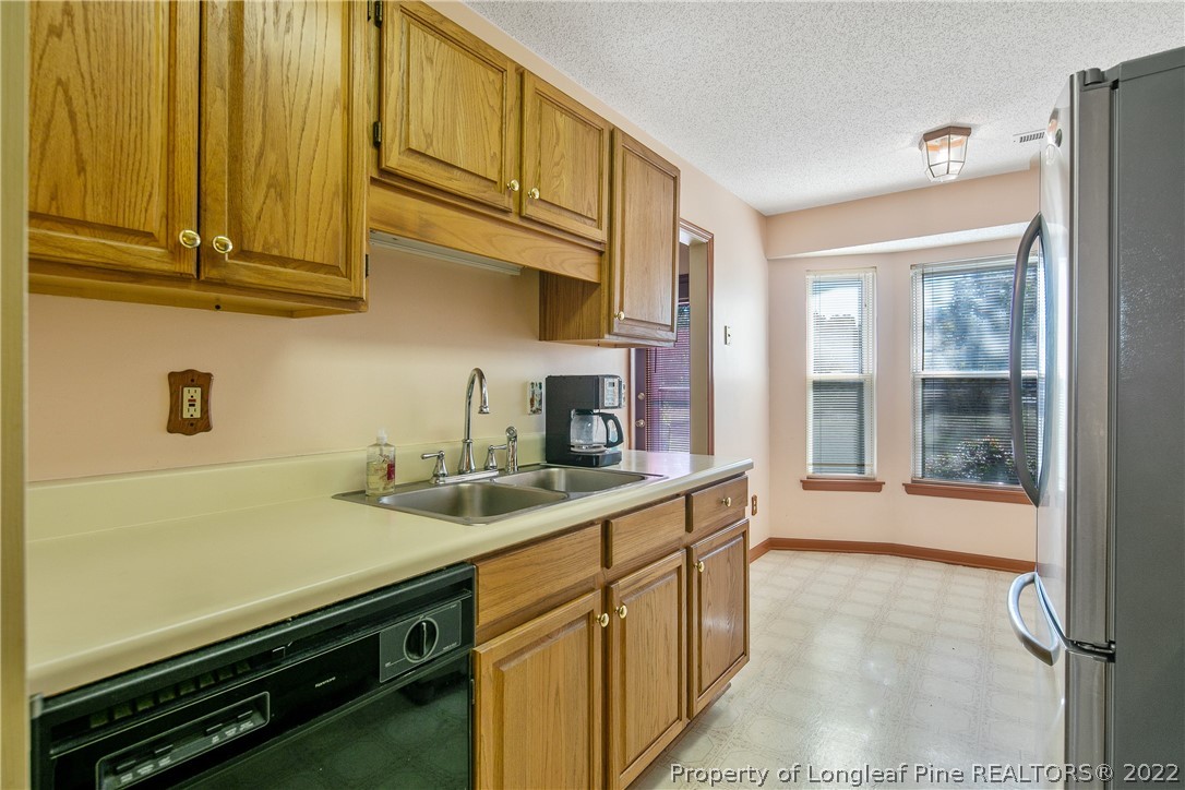 7455 Elliott Bridge Road Spring Lake, NC 28390 - Photo 25 of 49 a kitchen with stainless steel appliances granite countertop a sink stove and cabinets