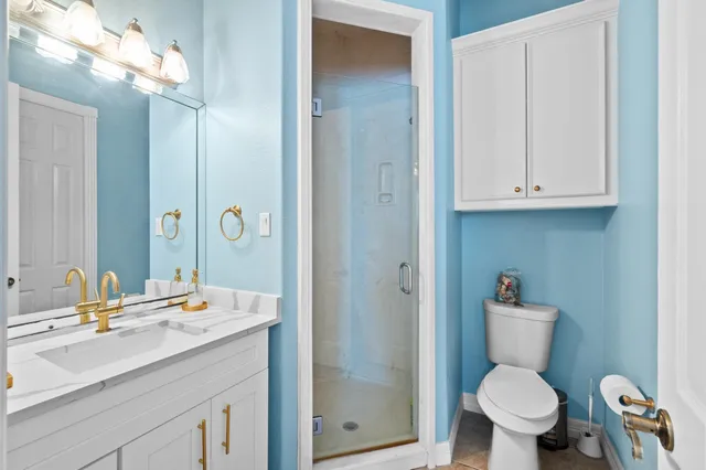 a bathroom with a sink a toilet and shower