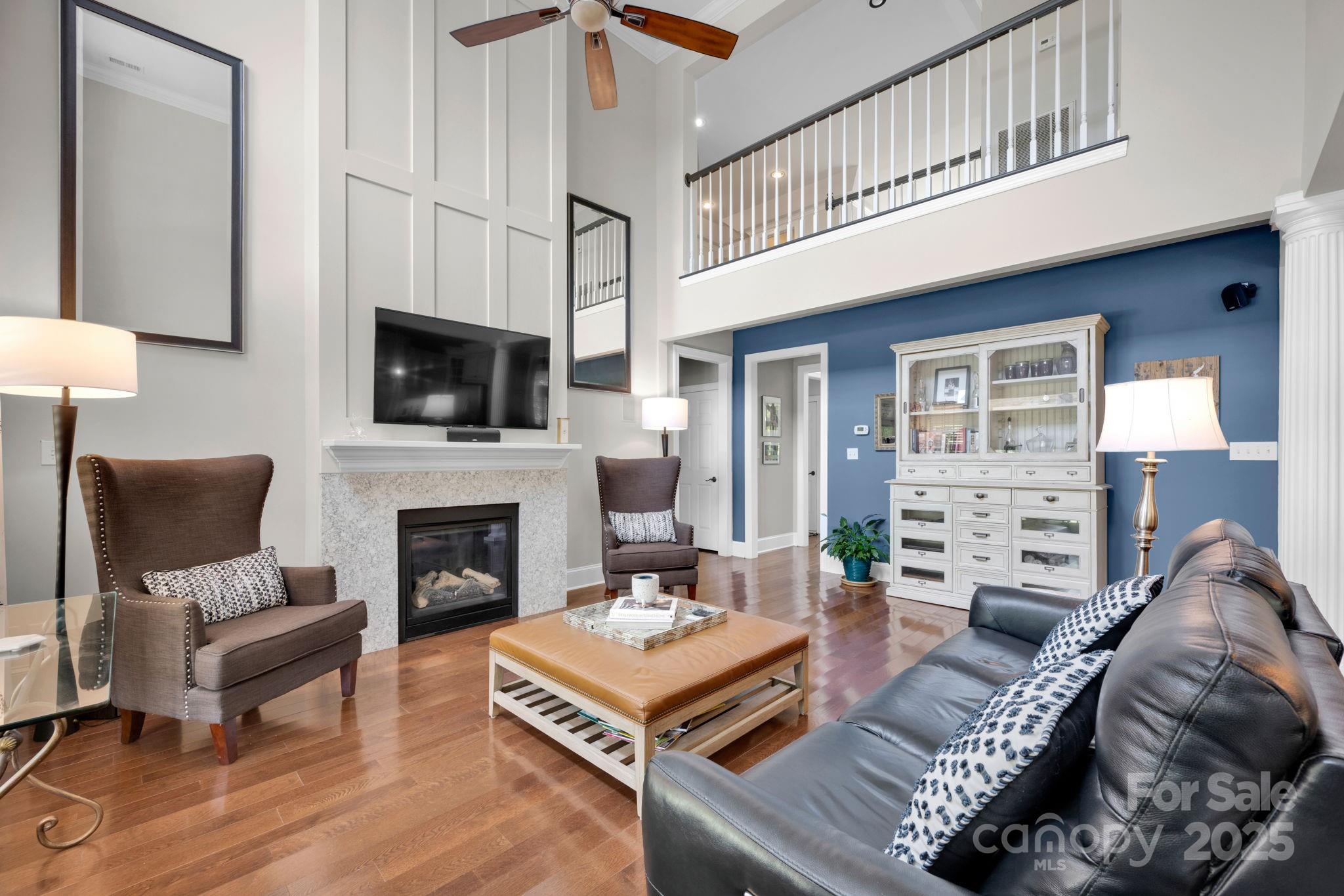 19577 Meta Road Cornelius, NC 28031 - Photo 17 of 45 a living room with furniture a fireplace and a flat screen tv