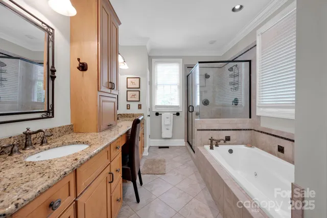 a bathroom with a granite countertop tub sink and mirror