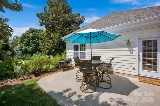 a view of a backyard with table and chairs under an umbrella