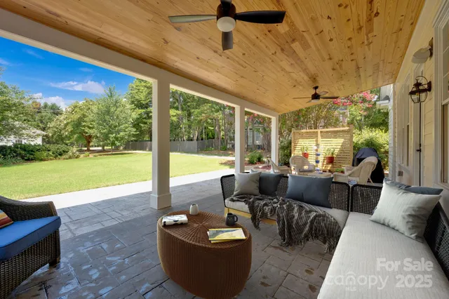 a living room with patio furniture and a floor to ceiling window