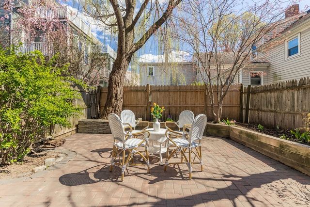 a view of a chairs and table in backyard
