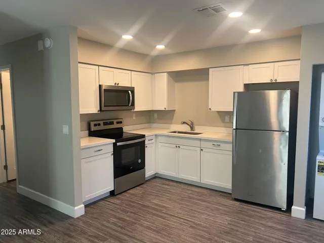 a kitchen with a refrigerator stove and wooden cabinets