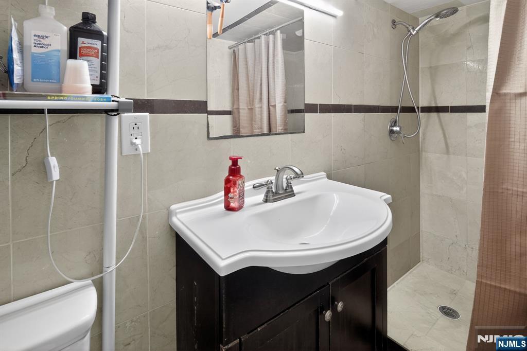 317 Ridge Road Rutherford, NJ 07070 - Photo 27 of 32 a bathroom with a sink and a mirror