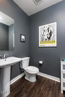 a bathroom with a toilet a sink and mirror