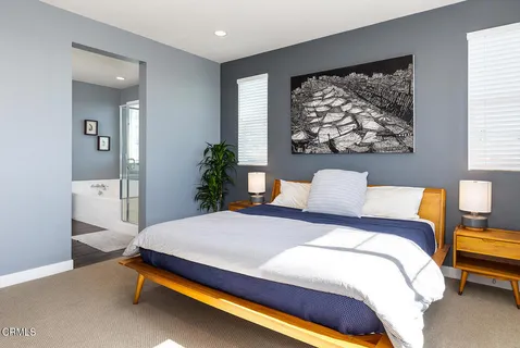 a bedroom with a bed and a painting on the wall