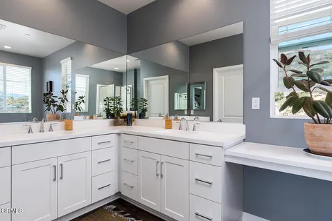 a bathroom with a sink and mirror with window