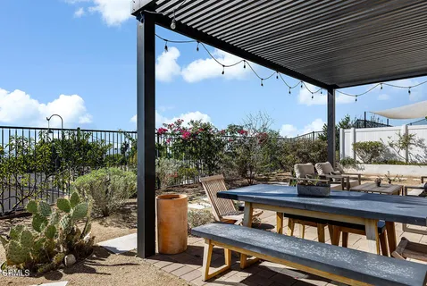 a roof deck with table and chairs potted plants with wooden floor
