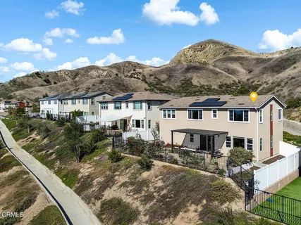 a front view of residential houses with yard and mountain view in back
