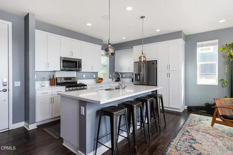 a kitchen with kitchen island a sink stove and refrigerator