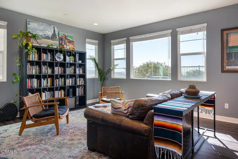 a living room with furniture a bookshelf and a window