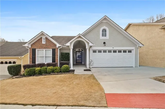 a view of a white house with large windows and a small yard