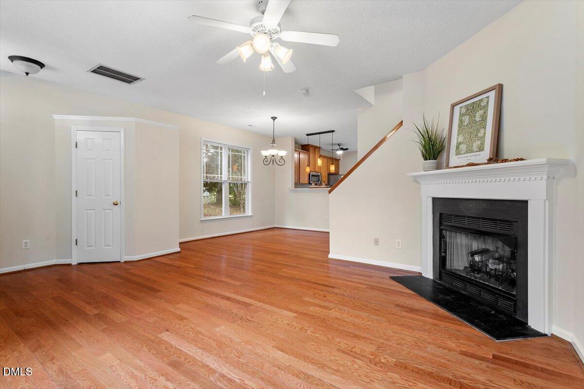 1039 Dual Parks Road Apex, NC 27502 - Photo 11 of 46 a view of empty room with wooden floor fireplace and fan