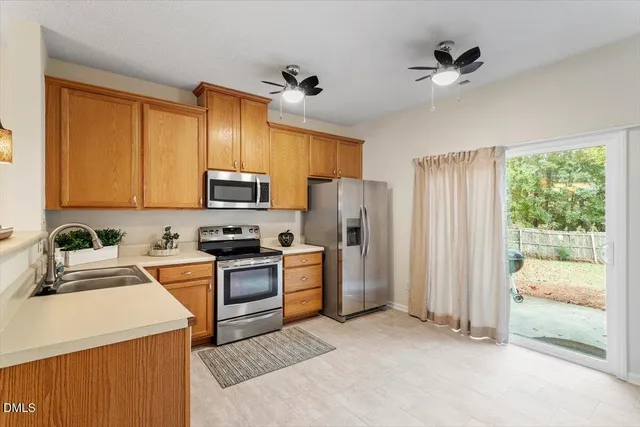a kitchen with stainless steel appliances a refrigerator sink and microwave