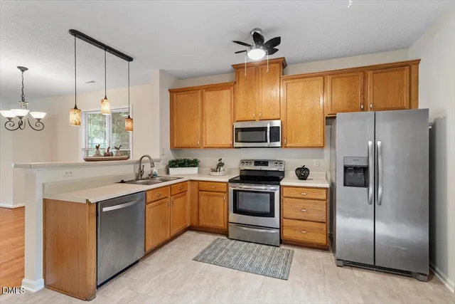 a kitchen with stainless steel appliances granite countertop a sink and cabinets with wooden floor