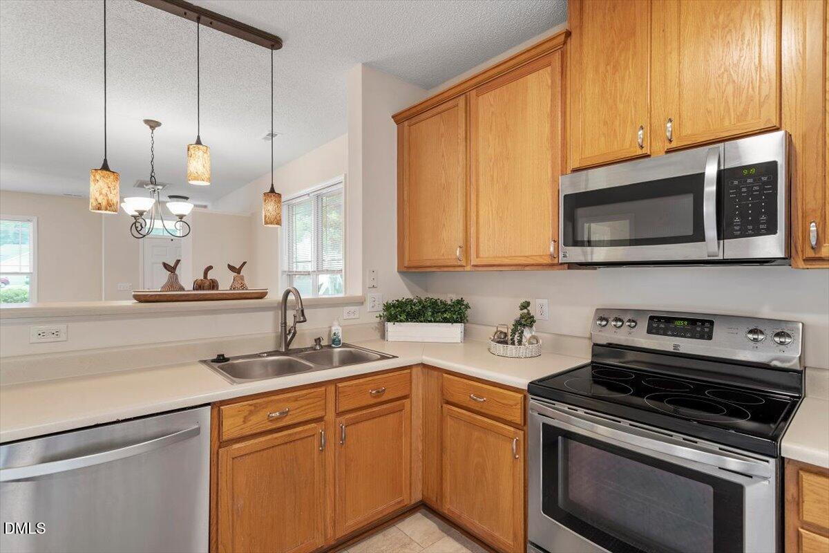 1039 Dual Parks Road Apex, NC 27502 - Photo 21 of 46 a kitchen with stainless steel appliances granite countertop a sink a stove and a microwave