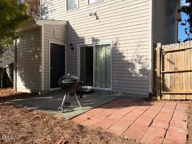 a view of a backyard with large trees and wooden fence