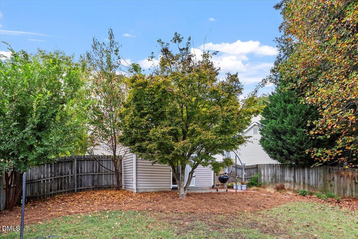 1039 Dual Parks Road Apex, NC 27502 - Photo 35 of 46 a view of a backyard with large trees and wooden fence
