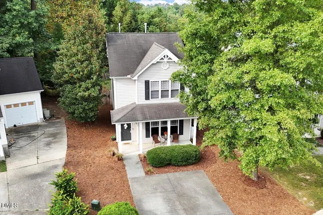 an aerial view of residential houses with outdoor space and trees