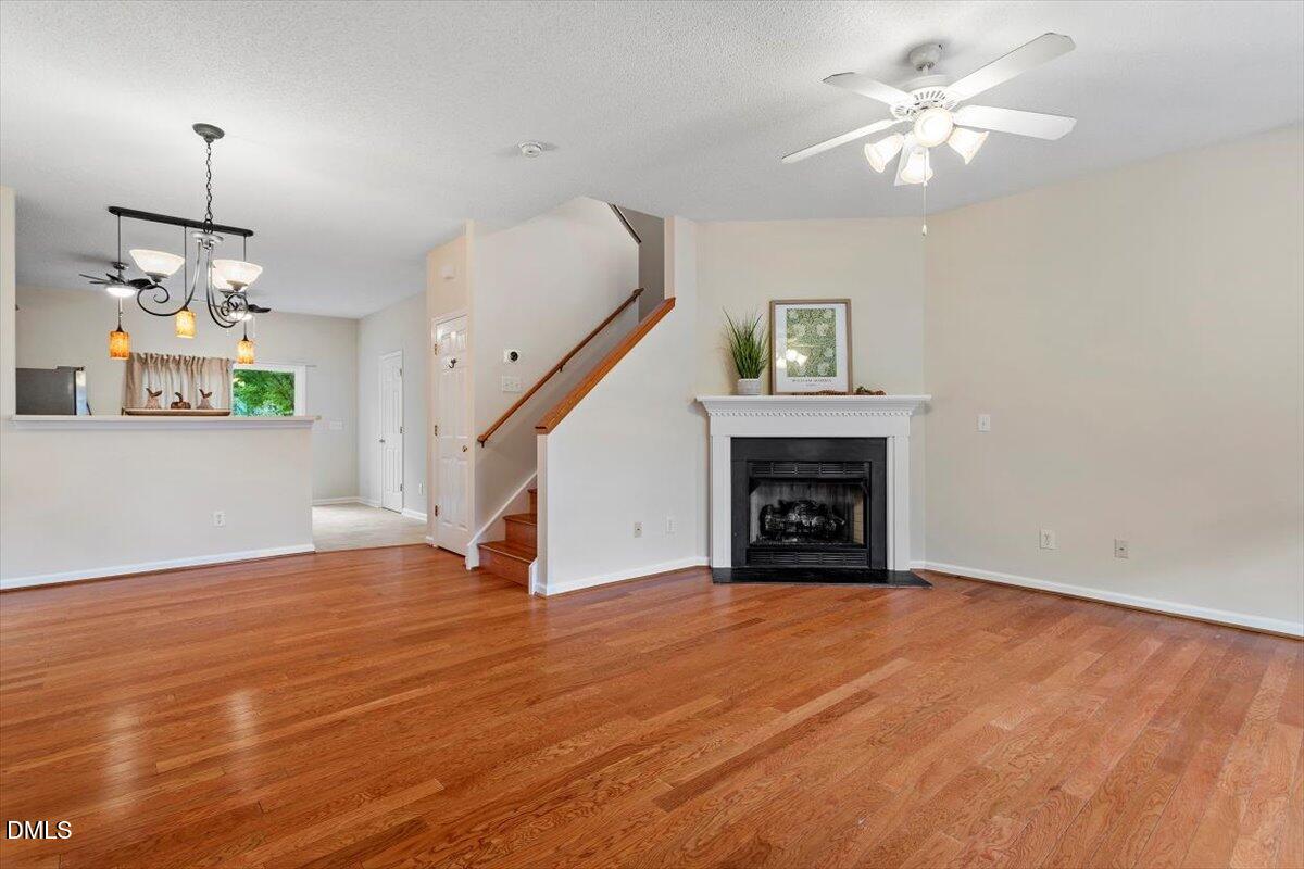 1039 Dual Parks Road Apex, NC 27502 - Photo 7 of 46 a view of an empty room with wooden floor fireplace and a window