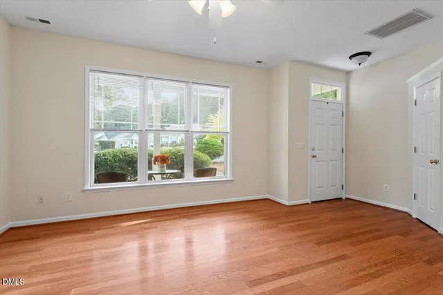 a view of empty room with wooden floor fireplace and fan