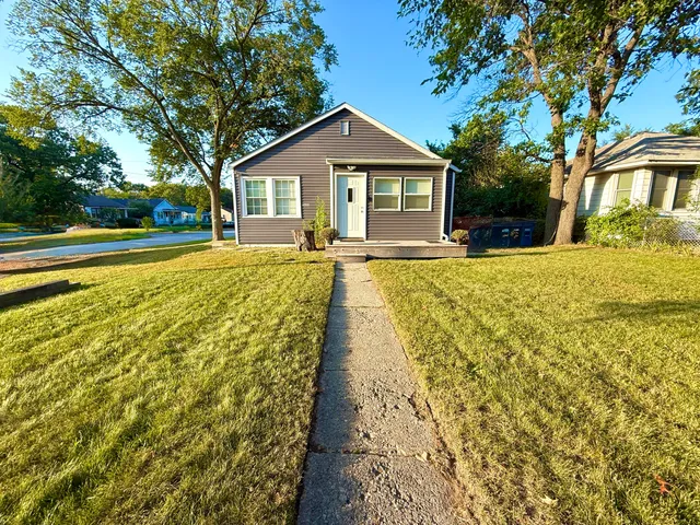 a front view of a house with yard and green space
