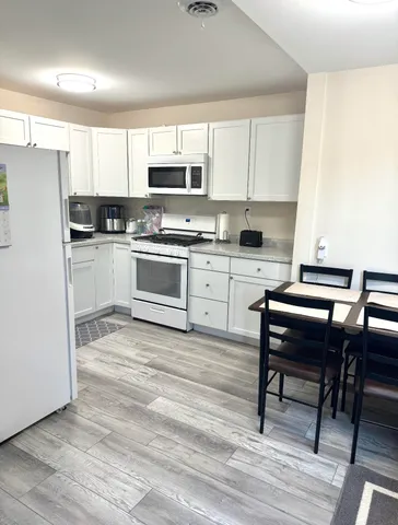 a kitchen with a white cabinets and white appliances