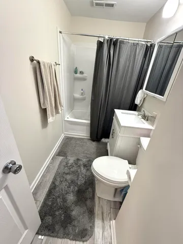 a white toilet sitting next to a shower curtain