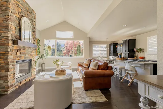 a living room with fireplace furniture and a large window