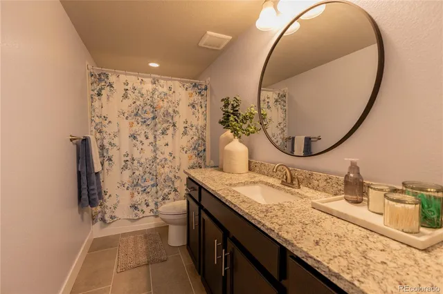 a bathroom with a granite countertop sink a toilet and a mirror