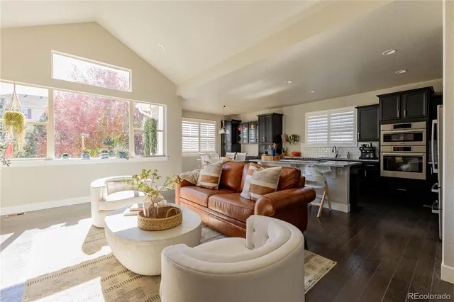 a living room with furniture kitchen and a large window