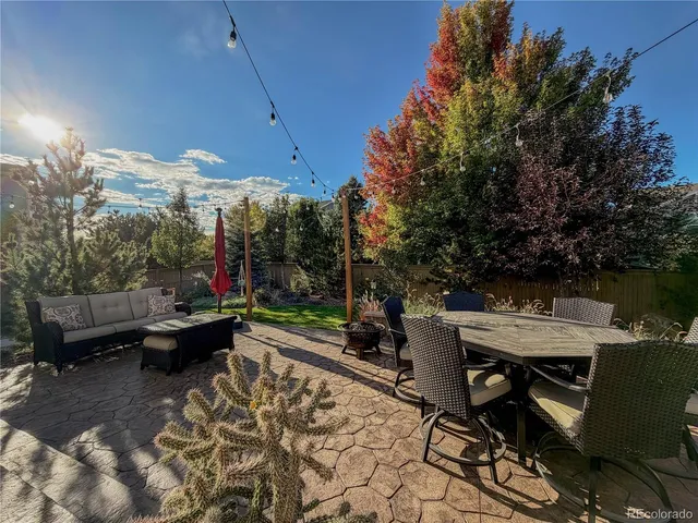a view of a patio with table and chairs a barbeque with wooden floor and fence