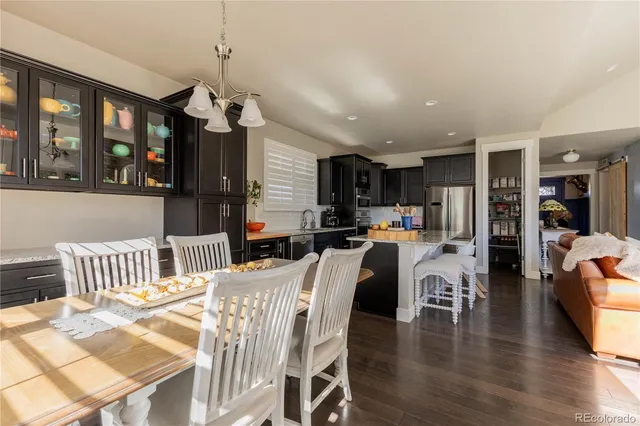 a view of a dining room and livingroom with furniture wooden floor a chandelier