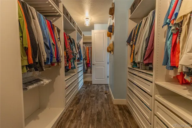a view of walk in closet with clothes and shoes