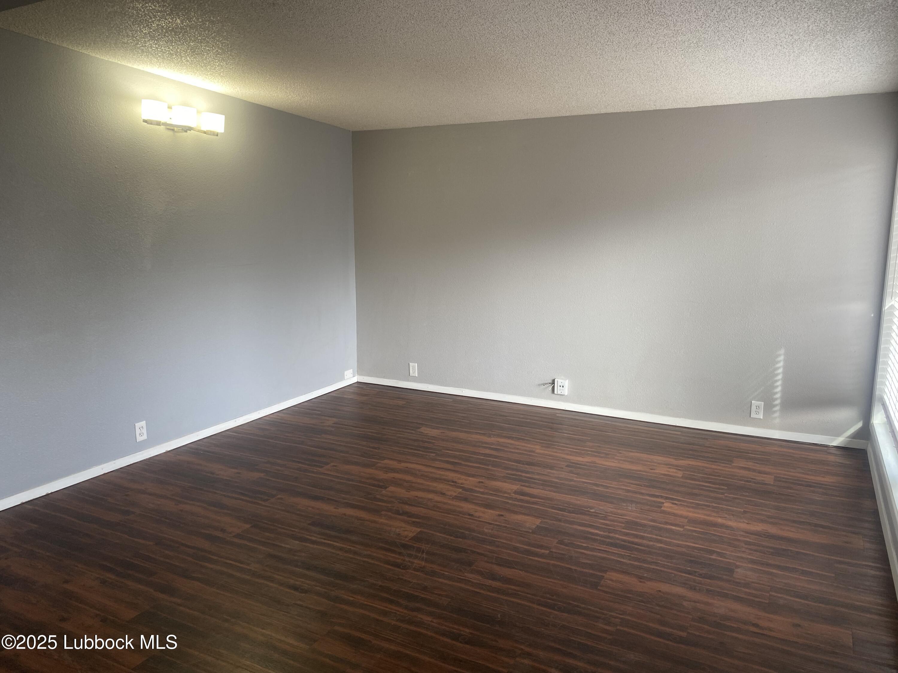 2704 68th Street Lubbock, TX 79413 - Photo 3 of 12 a view of an empty room with wooden floor