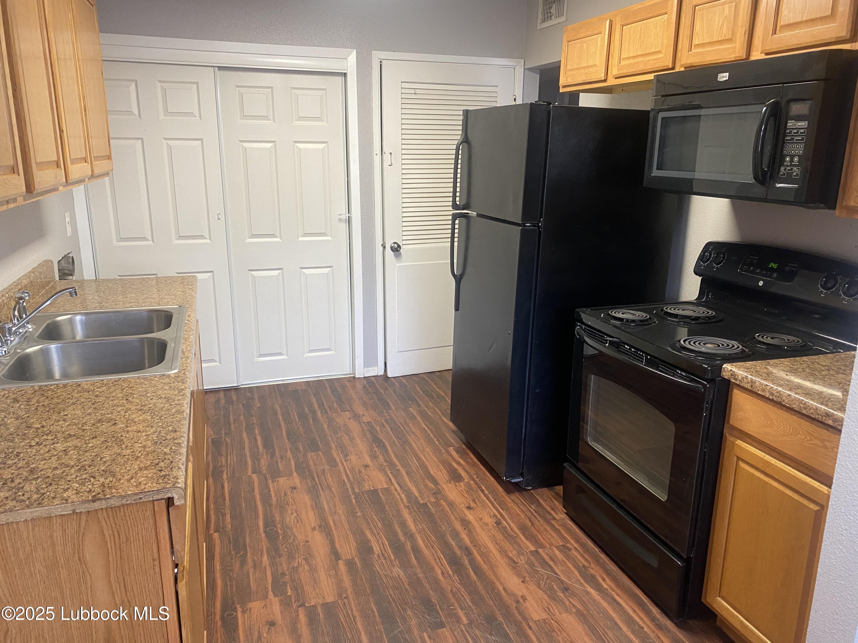 2704 68th Street Lubbock, TX 79413 - Photo 4 of 12 a kitchen with granite countertop a refrigerator stove and sink