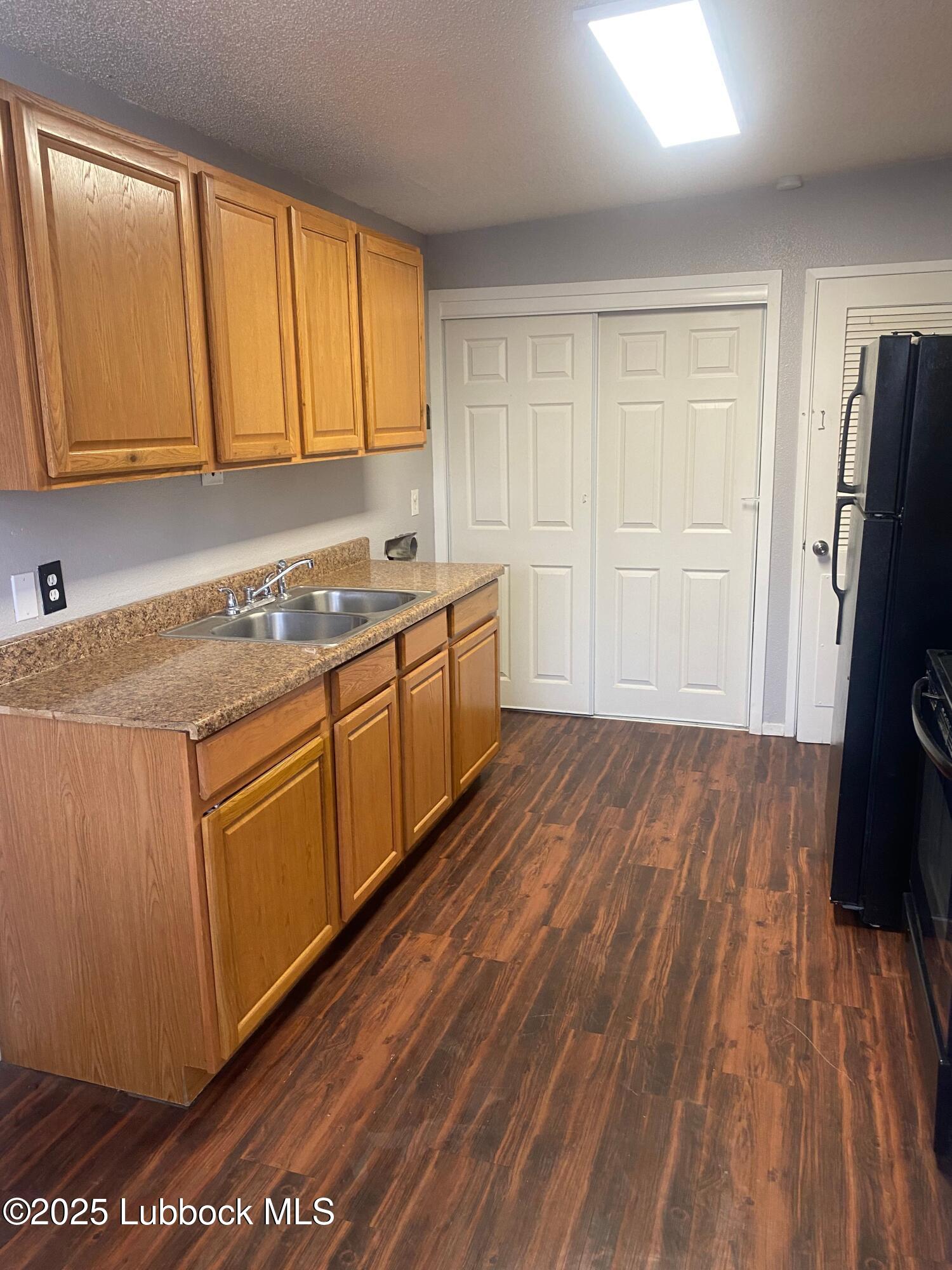 2704 68th Street Lubbock, TX 79413 - Photo 5 of 12 a kitchen with wooden floors and sink