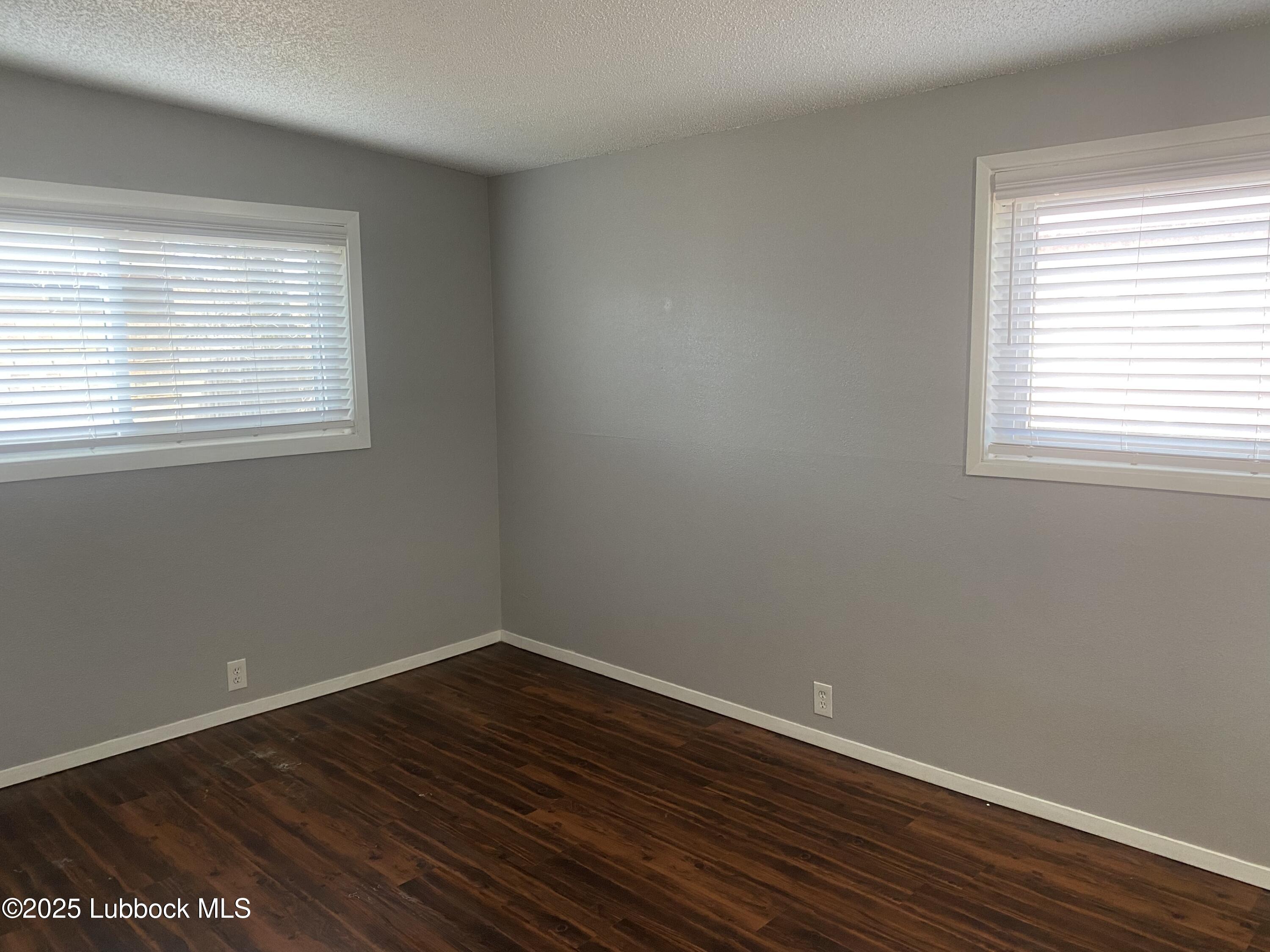 2704 68th Street Lubbock, TX 79413 - Photo 7 of 12 wooden floor in an empty room with a window
