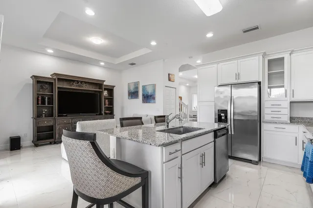 a kitchen with stainless steel appliances granite countertop a sink and a refrigerator