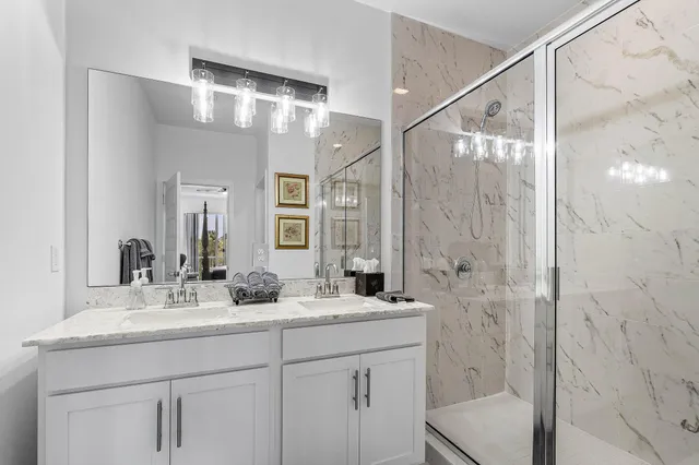 a bathroom with a double vanity sink mirror and shower