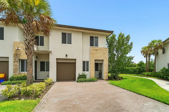 a front view of a house with yard and green space