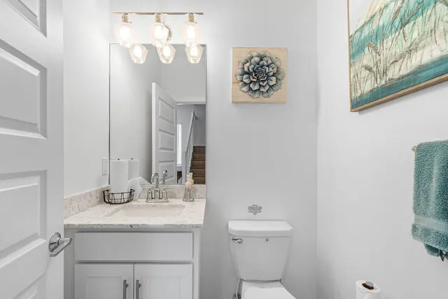 a bathroom with a granite countertop sink mirror and toilet