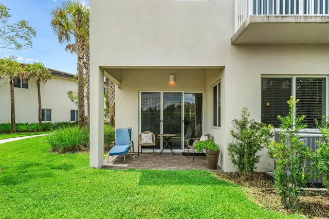a view of a chair and table in backyard of the house