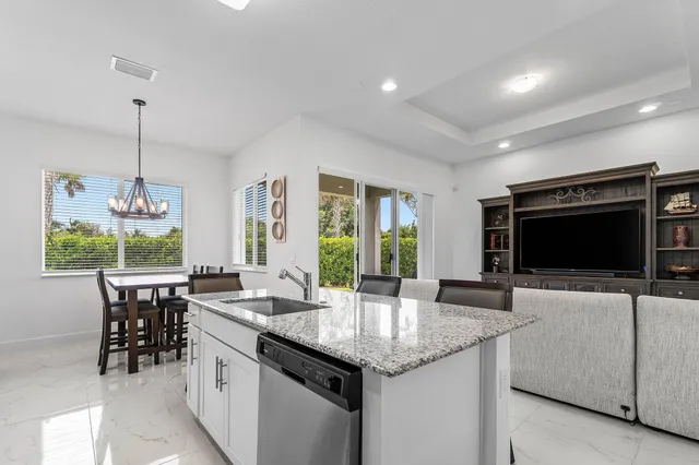 a kitchen with granite countertop a sink and a wooden floor