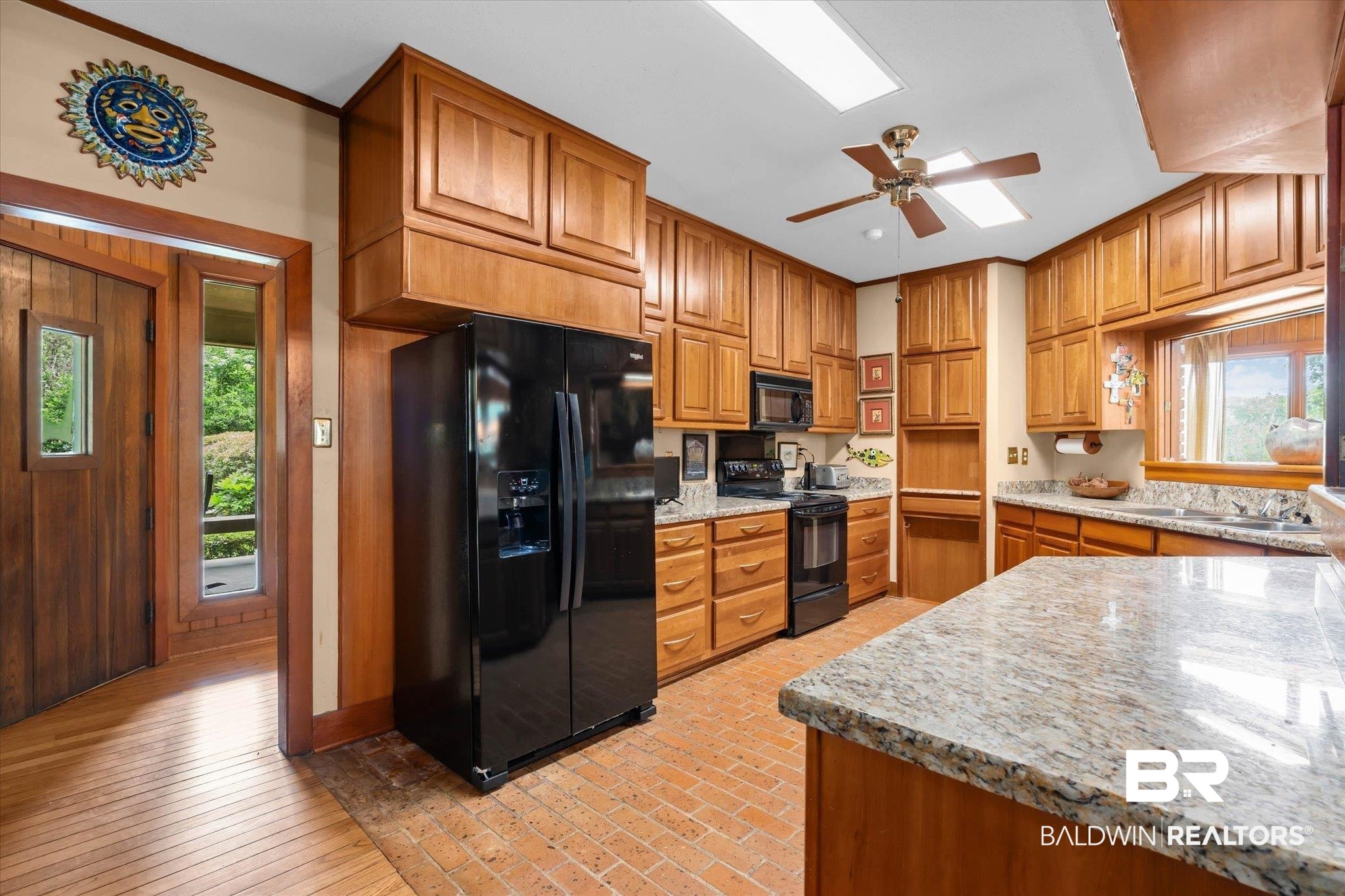 3500 Venetia Road Mobile, AL 36605 - Photo 7 of 56 Kitchen featuring extensive wood cabinetry, light-toned countertops, integrated black appliances, a brick-pattern floor, and a ceiling fan