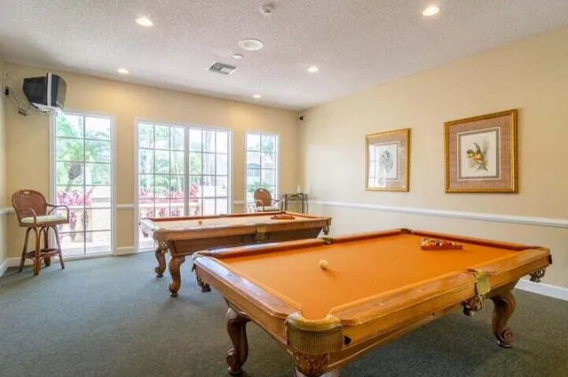 a room with pool table and windows