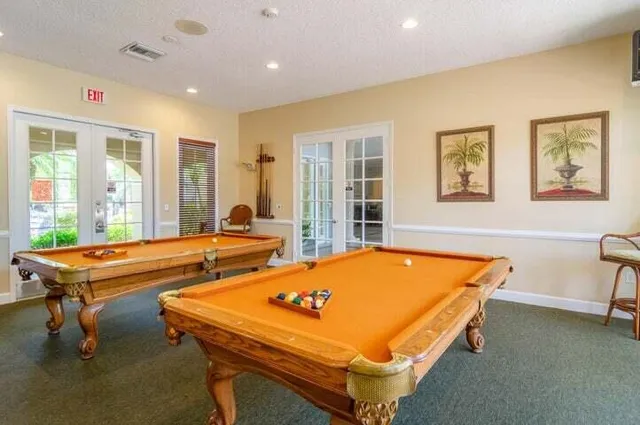 a room with pool table and windows